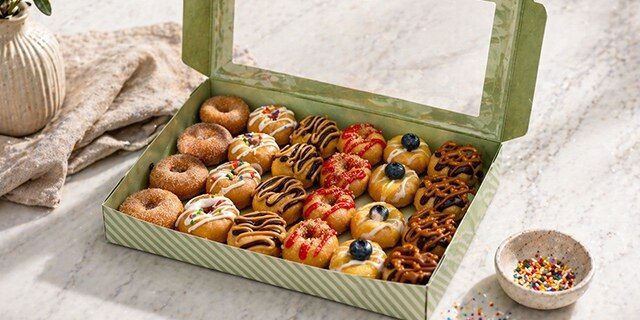 An assorted box of Dapper Doughnut mini doughnuts in a variety of flavors
